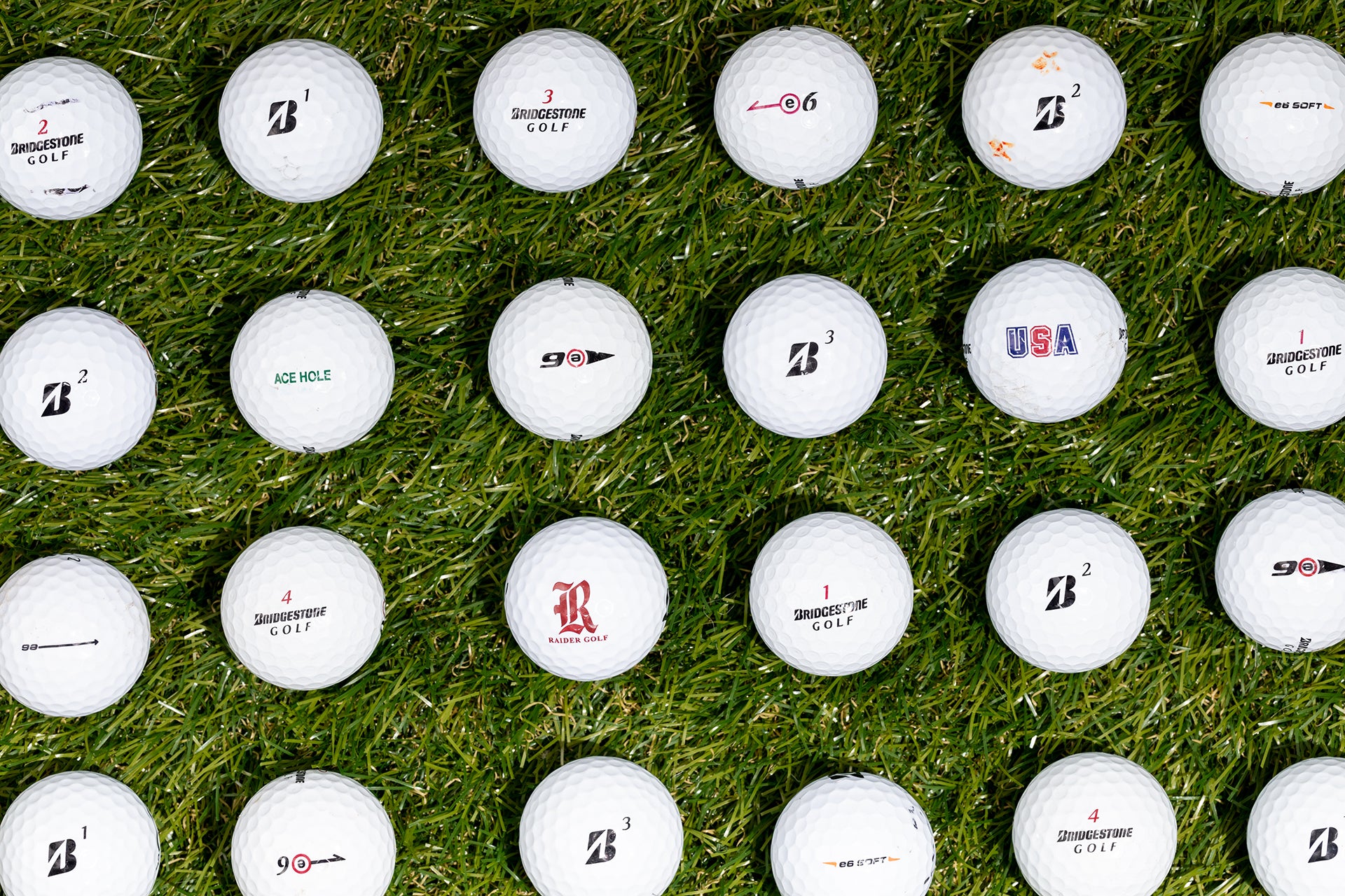 rows of recycled bridgestone e6 golf balls on green grass